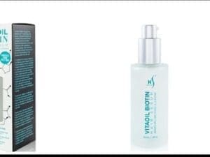 A bottle of VitaOil Biotin Nourish & Shine Hair Serum in front of a box.